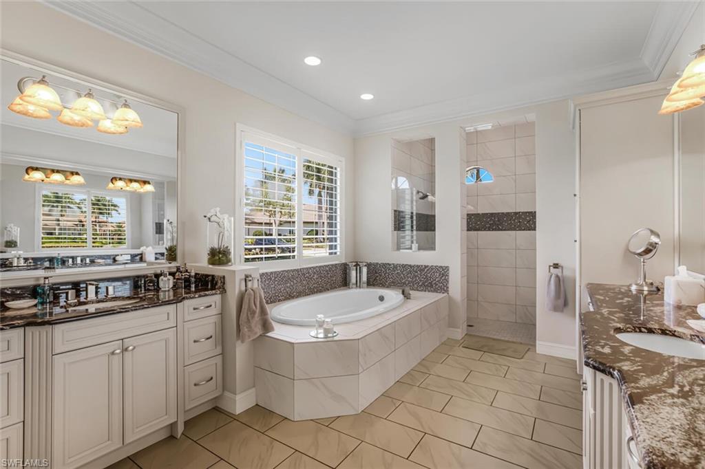 6624 Barbera Lane Naples, FL 34113 - Photo 22 of 50 a spacious bathroom with a granite countertop tub sink and mirror