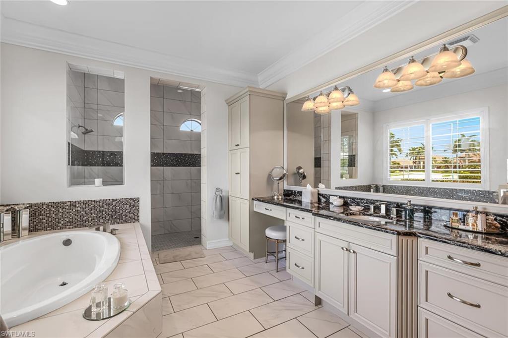 6624 Barbera Lane Naples, FL 34113 - Photo 23 of 50 a spacious bathroom with a granite countertop sink mirror and bathtub