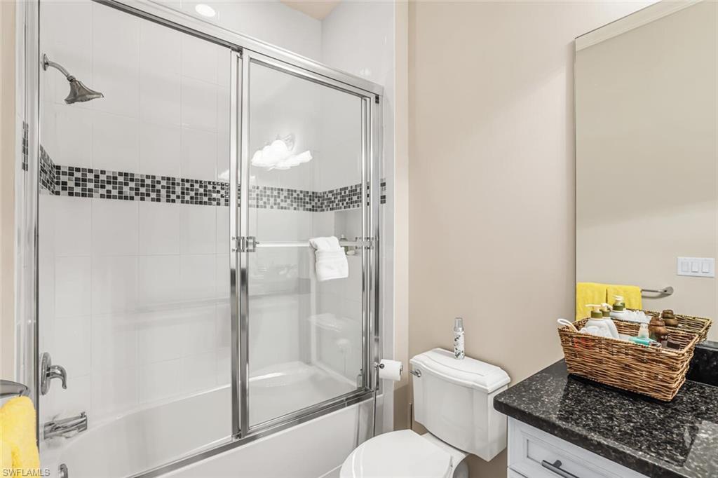 6624 Barbera Lane Naples, FL 34113 - Photo 27 of 50 a bathroom with a granite countertop sink mirror vanity and toilet
