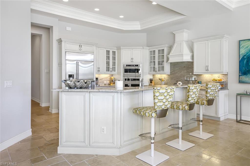 6624 Barbera Lane Naples, FL 34113 - Photo 5 of 50 a kitchen with stainless steel appliances kitchen island granite countertop a table and chairs in it