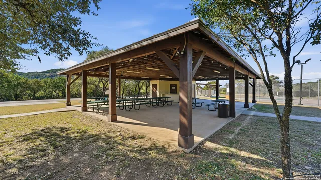 a view of a patio with table and chairs near a barbeque