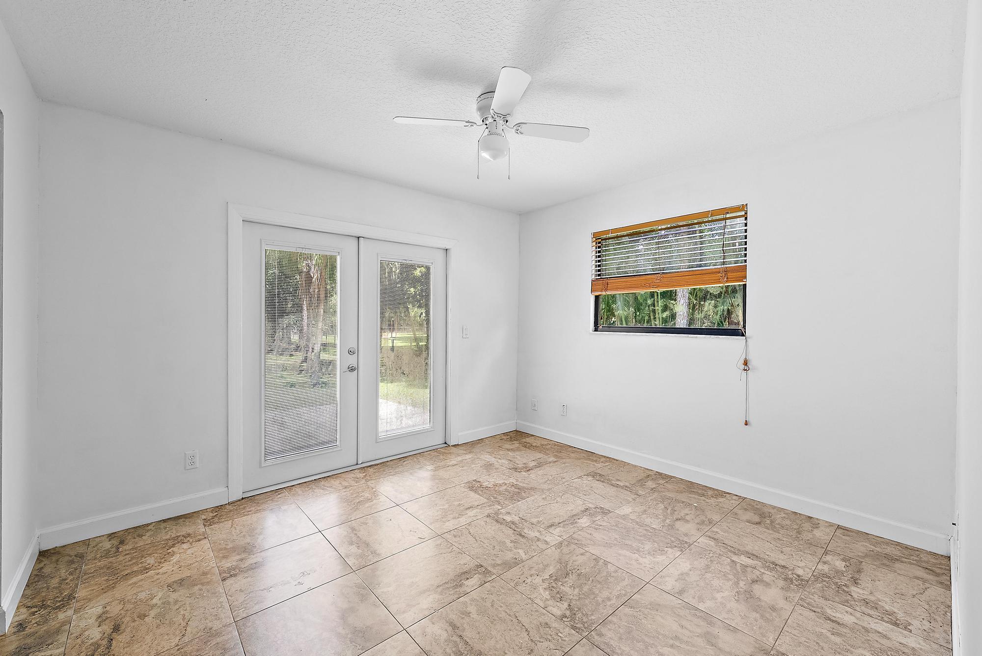 18222 126th Terrace North Jupiter, FL 33478 - Photo 11 of 22 an empty room with windows and ceiling fan