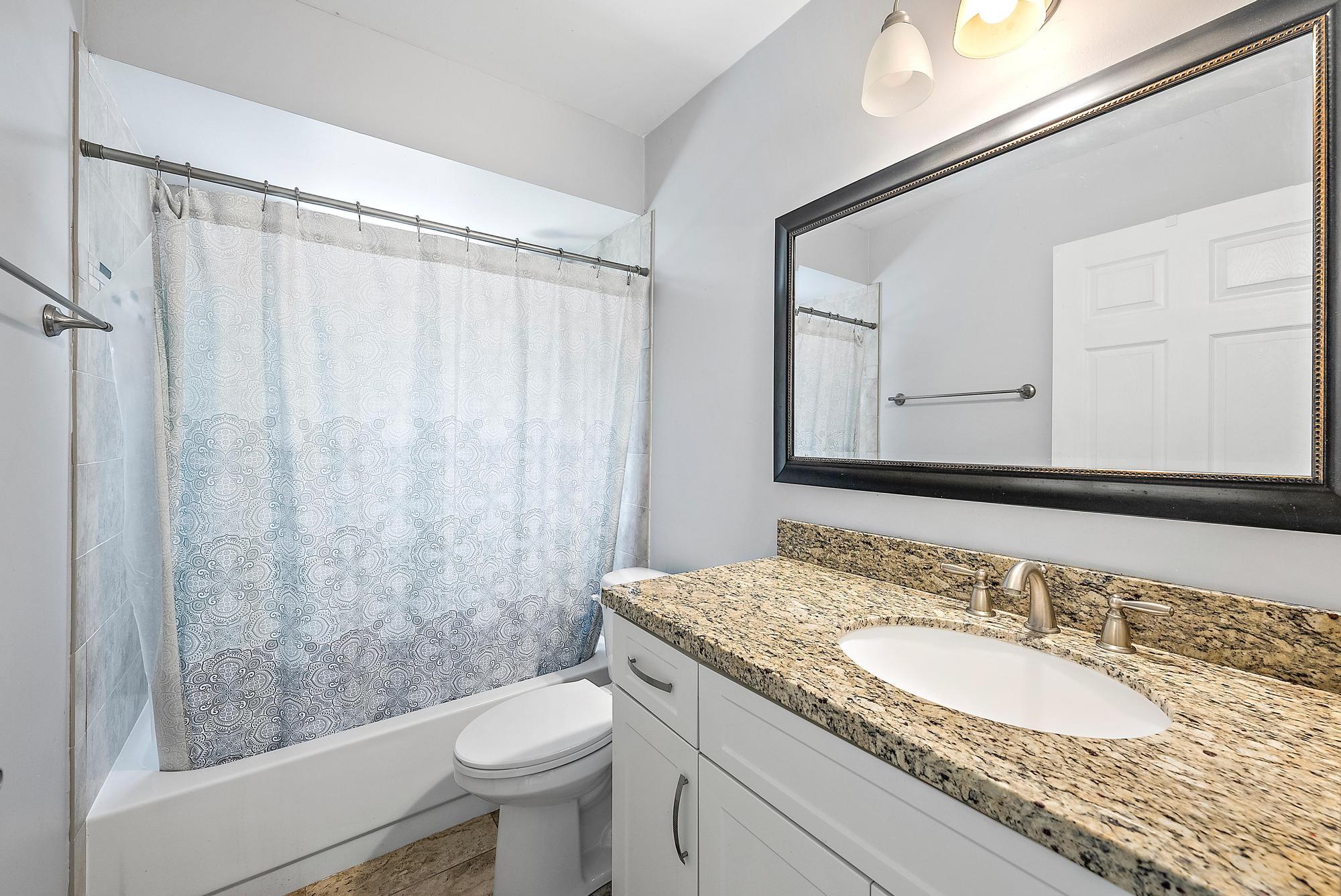 18222 126th Terrace North Jupiter, FL 33478 - Photo 10 of 22 a bathroom with a granite countertop sink toilet and shower