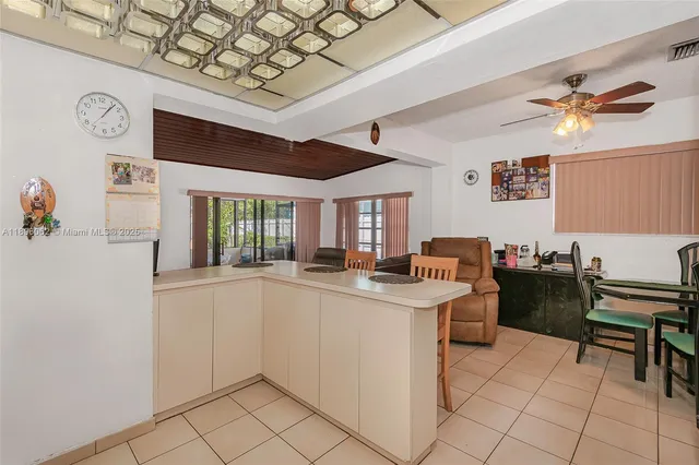 a kitchen with granite countertop lots of counter top space dining table and stainless steel appliances