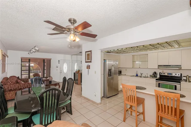 a kitchen with stainless steel appliances granite countertop a refrigerator a stove a sink and a refrigerator with wooden floor