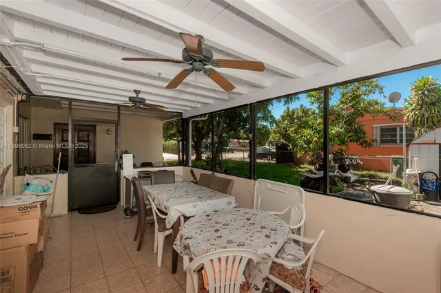 a backyard of a house with wooden fence and a tree