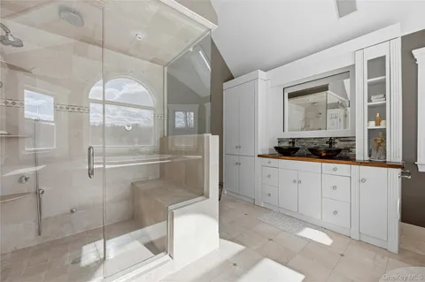 a bathroom with a glass shower door and a sink