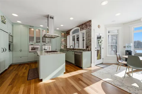 a kitchen with stainless steel appliances kitchen island granite countertop a refrigerator and a stove top oven