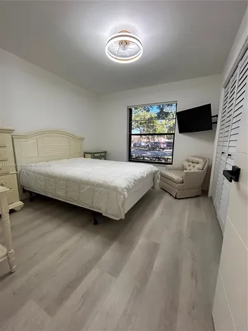 a bedroom with a bed and a flat tv screen on dresser
