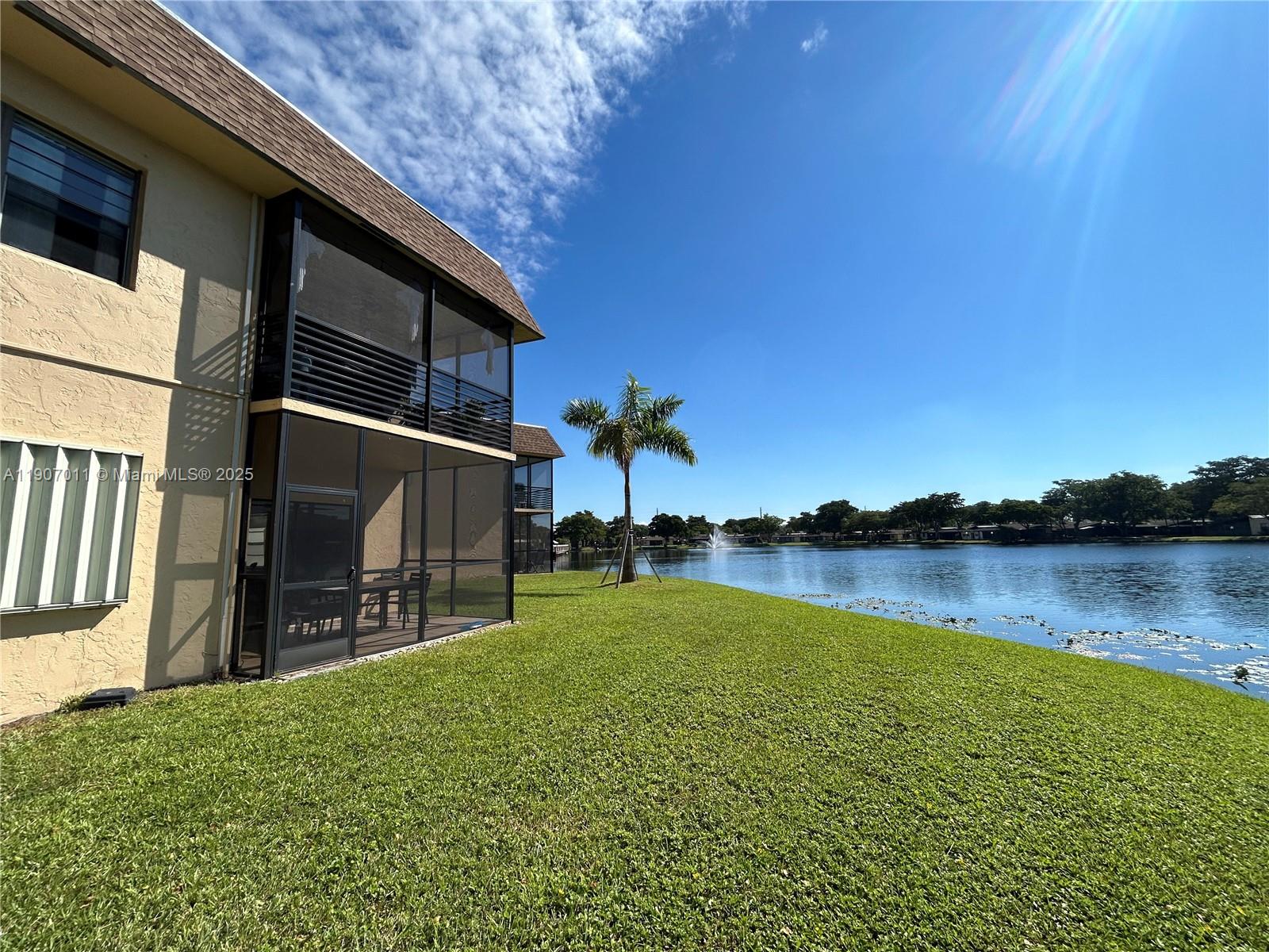 200 Berkley Road, Unit 113 Hollywood, FL 33024 - Photo 36 of 38 a backyard of a house with lake view and a floor to ceiling window