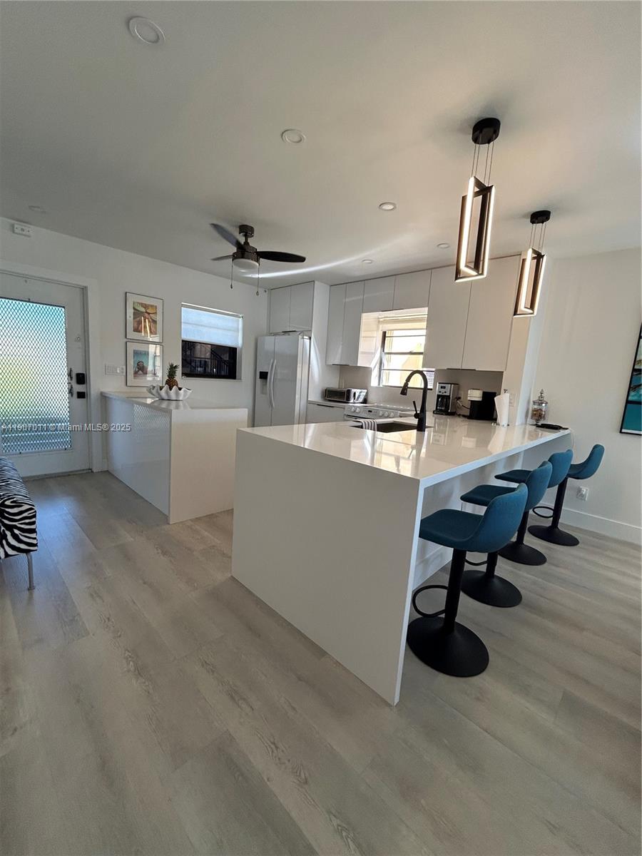 200 Berkley Road, Unit 113 Hollywood, FL 33024 - Photo 6 of 38 a living room with furniture and a chandelier