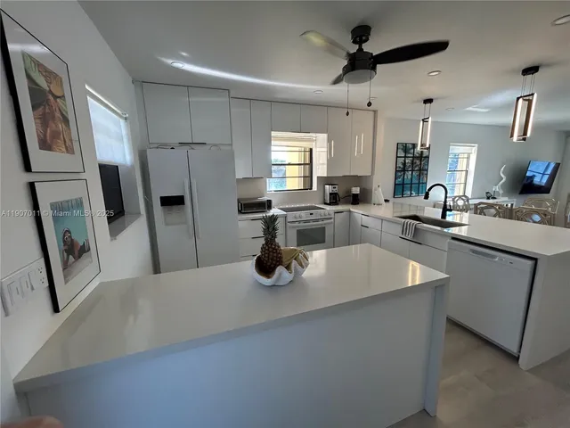 a kitchen with stainless steel appliances granite countertop a sink a stove and refrigerator