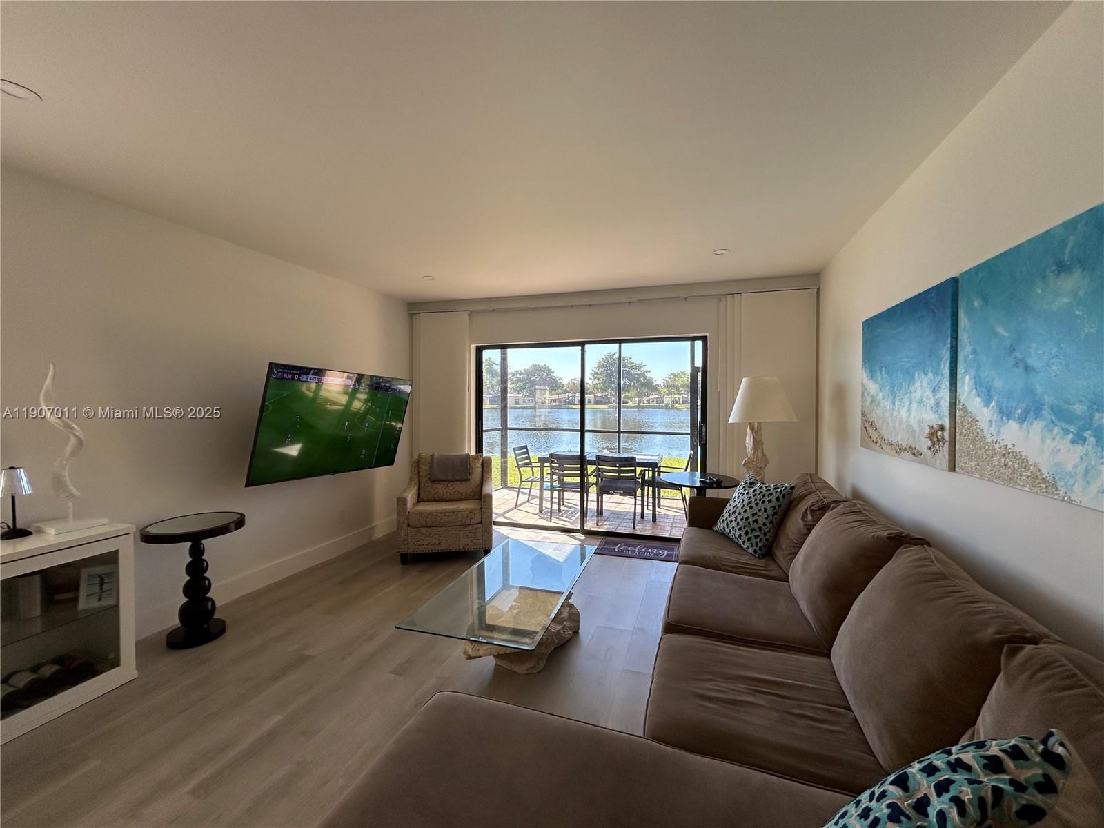 200 Berkley Road, Unit 113 Hollywood, FL 33024 - Photo 10 of 38 a living room with furniture and a flat screen tv