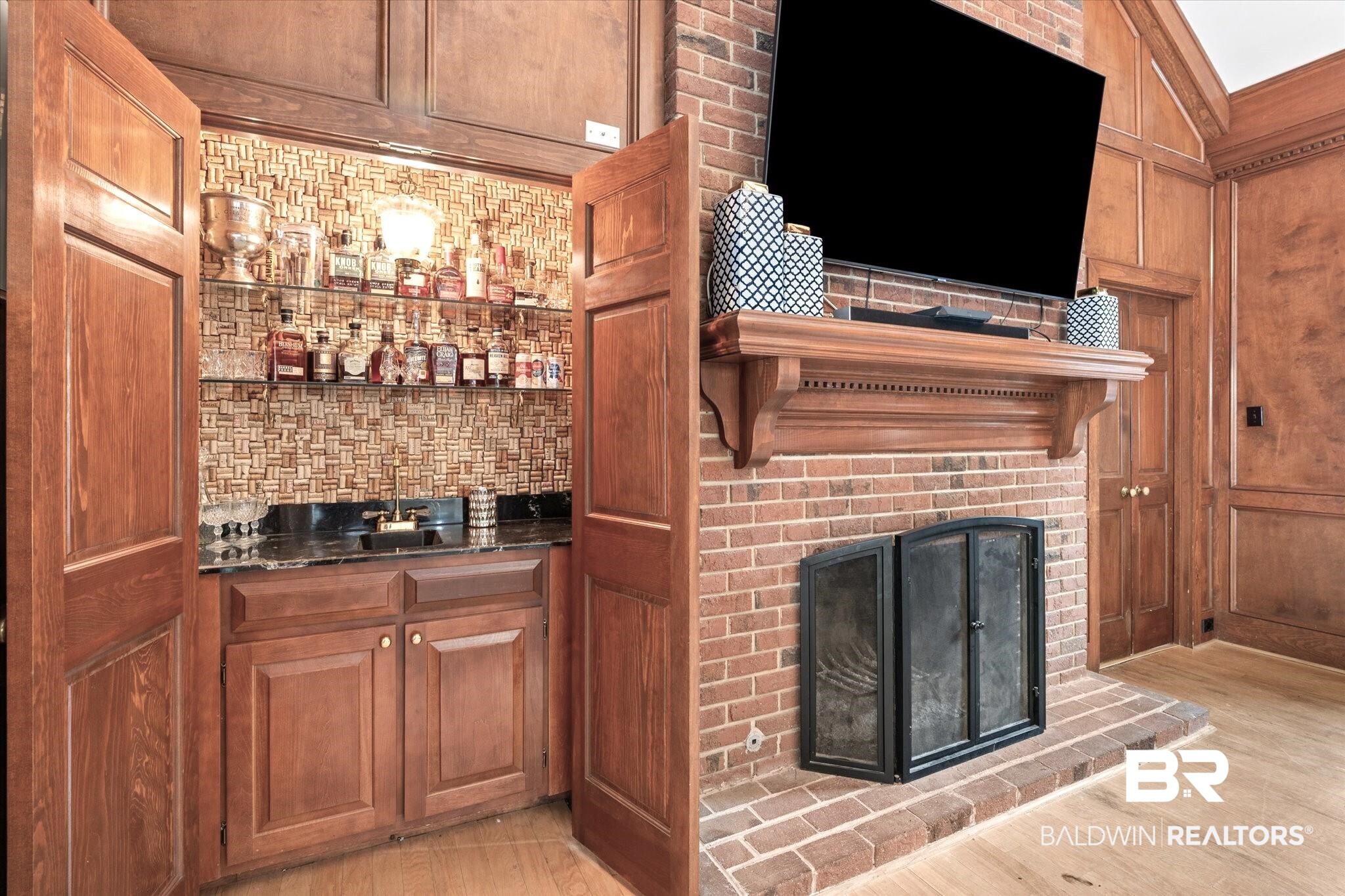 5324 Oak Bend Court Mobile, AL 36609 - Photo 15 of 49 Bar with a fireplace, light wood-style floors, wet bar, and decorative backsplash