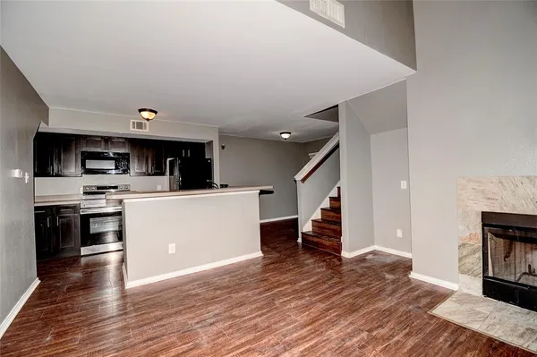 a view of kitchen with microwave stove refrigerator and cabinets