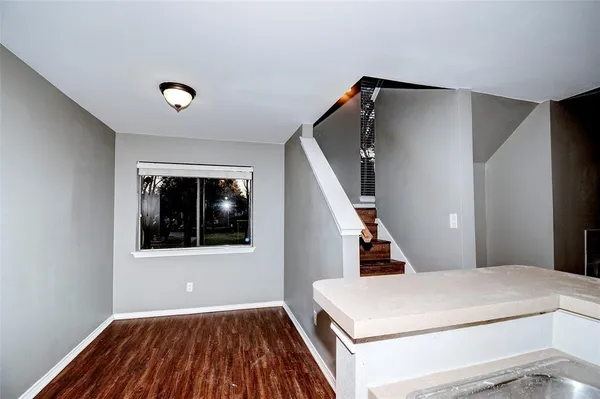 a view of a livingroom with wooden floor and staircase