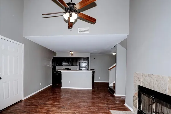 a view of a kitchen with a sink a refrigerator and wooden floor