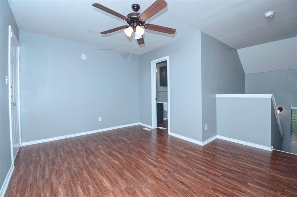 9831 Walnut Street, Unit 209 Dallas, TX 75243 - Photo 10 of 26 an empty room with wooden floor and a ceiling fan
