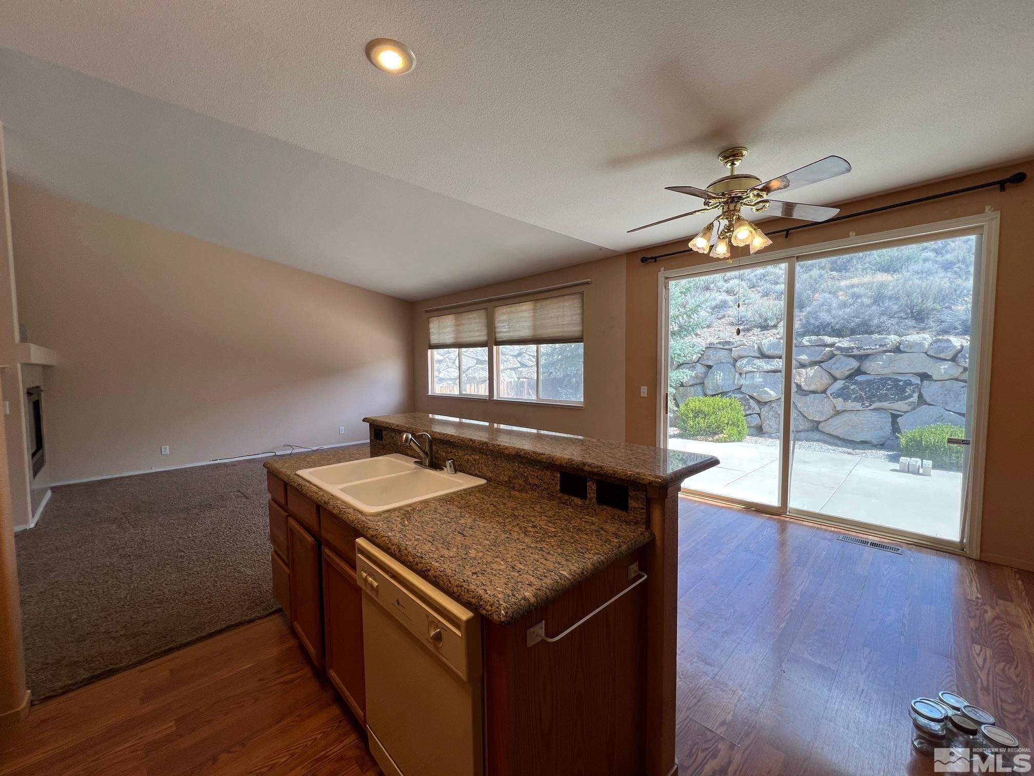 5458 Zeppelin Court Reno, NV 89523 - Photo 5 of 36 a kitchen with a counter space wooden floor and a ceiling fan