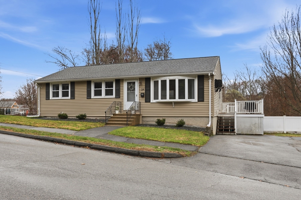 a view of a house with backyard and trees in the background