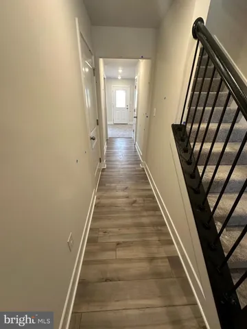 a view of a hallway with wooden floor and staircase