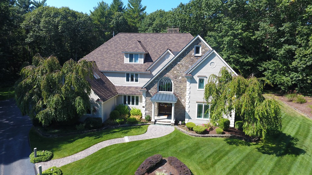 a aerial view of a house with yard and green space