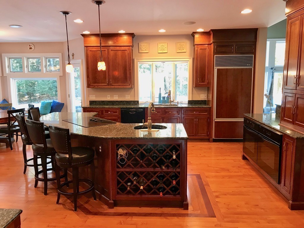 11 Kate's Lane Boxford, MA 01921 - Photo 17 of 30 a kitchen with stainless steel appliances granite countertop a stove a refrigerator a sink a dining table and chairs with wooden floor