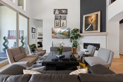 a living room with furniture fireplace and a large window