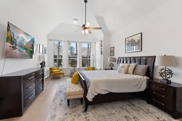 a bedroom with a bed and wooden floor