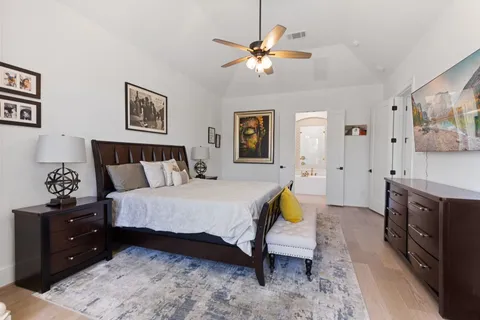 a spacious bedroom with a bed and a chandelier