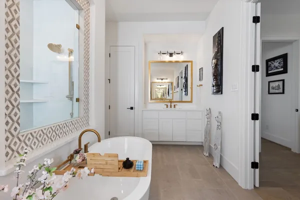 a bathroom with a sink and mirror with bathtub