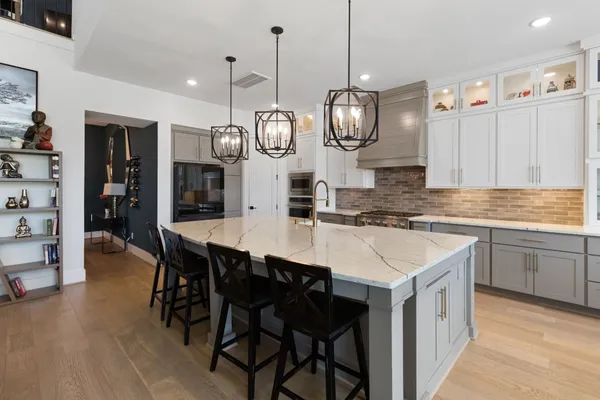 a kitchen with stainless steel appliances granite countertop a sink a stove and chairs
