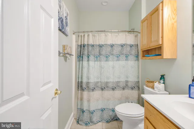 a view of a kitchen with kitchen island a counter top space a sink stainless steel appliances and cabinets