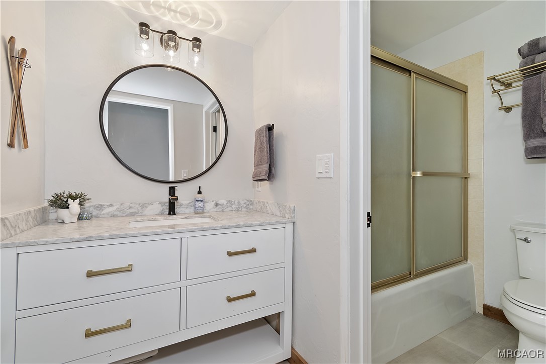 39343 Aurora Road Big Bear Lake, CA 92315 - Photo 34 of 50 a bathroom with a granite countertop toilet sink and mirror
