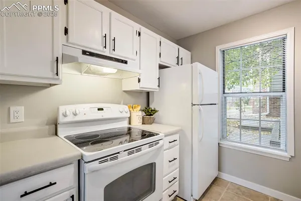 a kitchen with a stove a refrigerator and a window