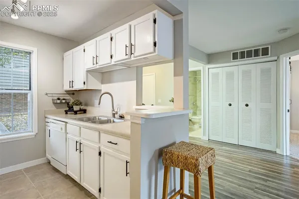 a kitchen with stainless steel appliances granite countertop a sink and cabinets with wooden floor