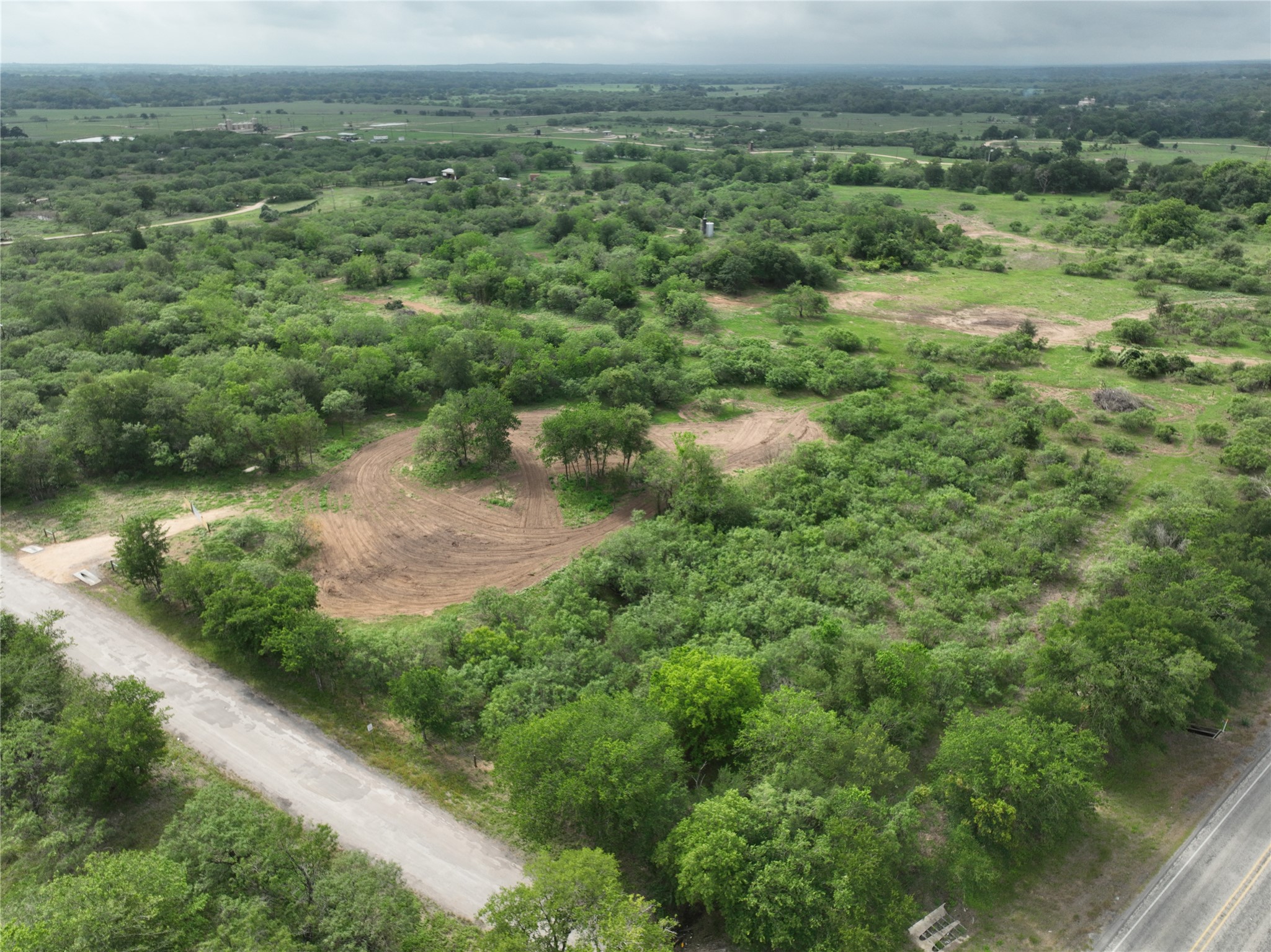 150 Pumper Road Luling, TX 78648 - Photo 2 of 24 A verdant, sprawling landscape with a road weaving through the natural terrain.
