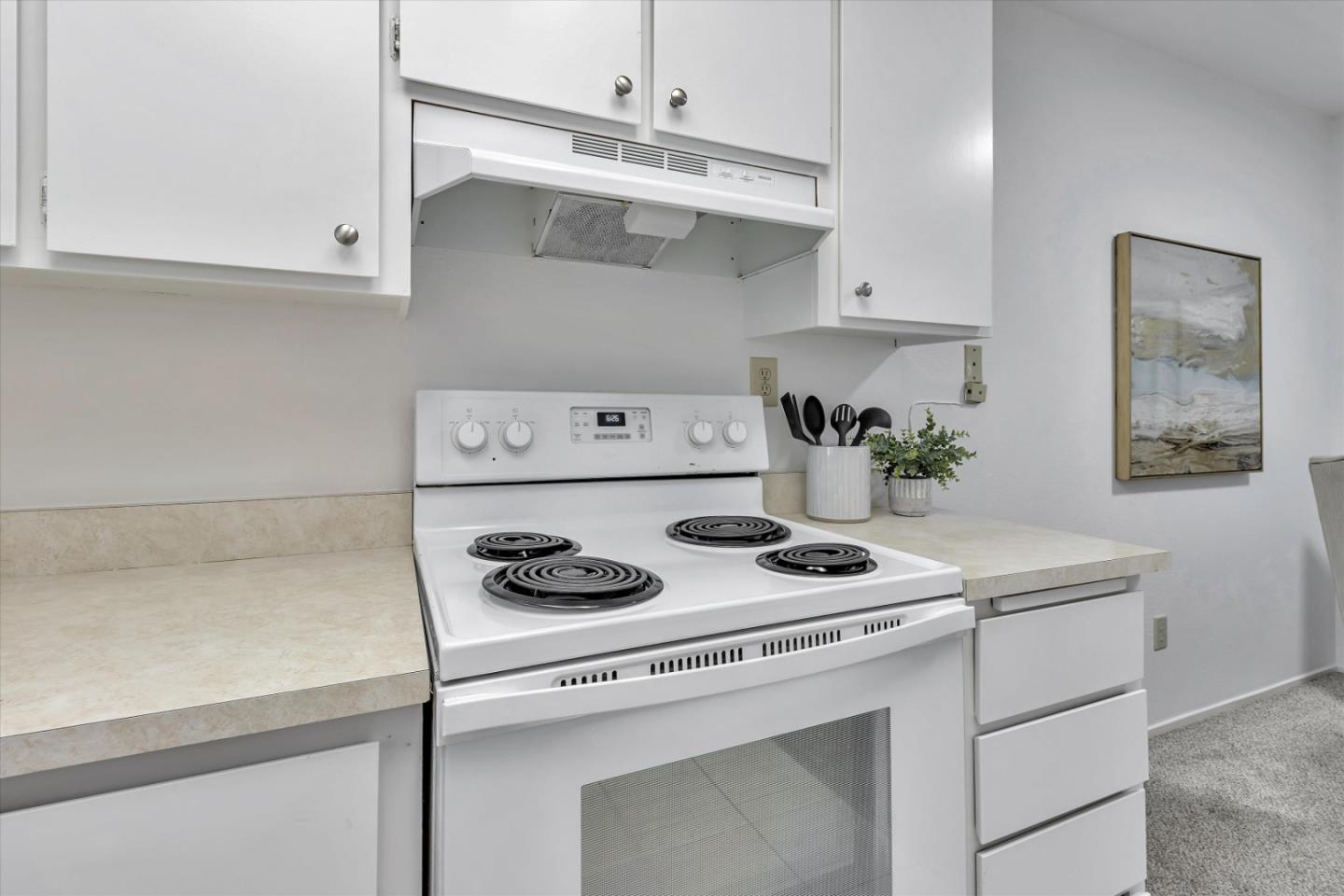 563 Shadow Dance Drive San Jose, CA 95110 - Photo 11 of 30 a kitchen with a stove and white cabinets