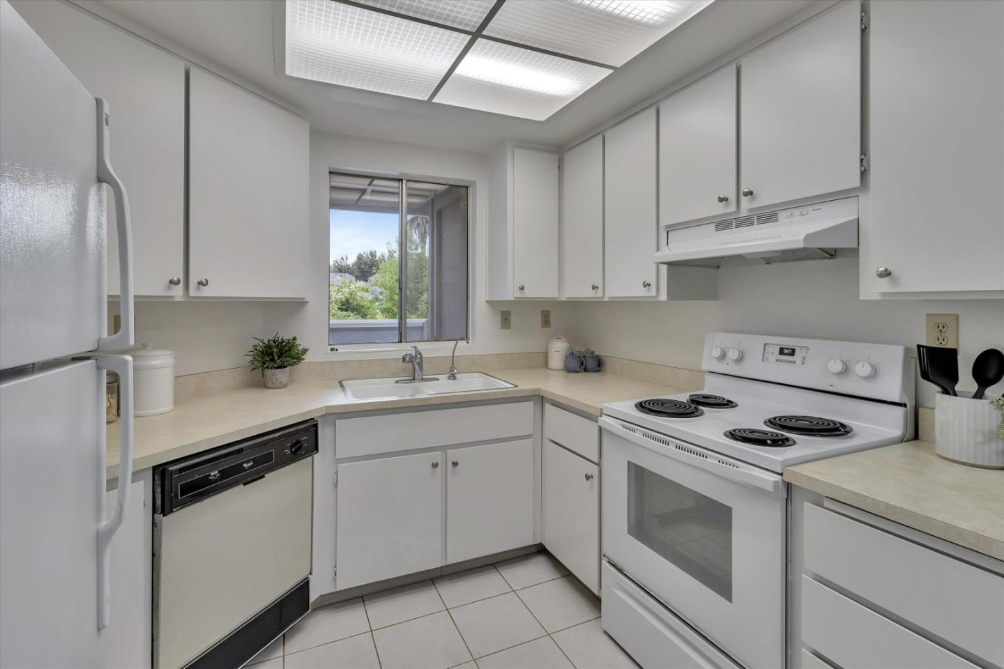 563 Shadow Dance Drive San Jose, CA 95110 - Photo 12 of 30 a kitchen with white cabinets stainless steel appliances and sink