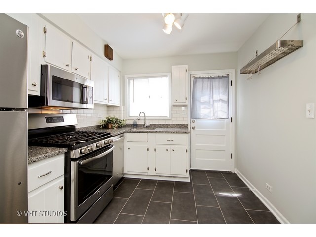 558 Green Bay Road Glencoe, IL 60022 - Photo 4 of 10 a kitchen with granite countertop a stove a sink and a microwave