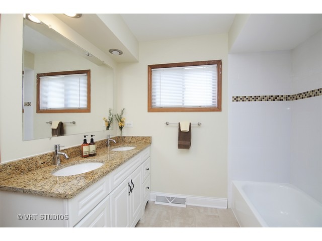 558 Green Bay Road Glencoe, IL 60022 - Photo 8 of 10 a bathroom with a granite countertop sink a mirror and a bathtub