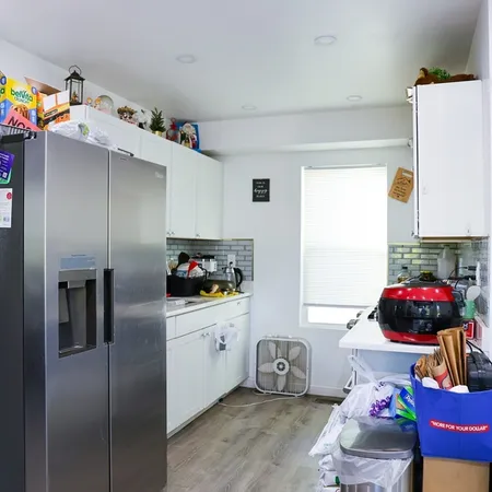a kitchen with white cabinets and sink