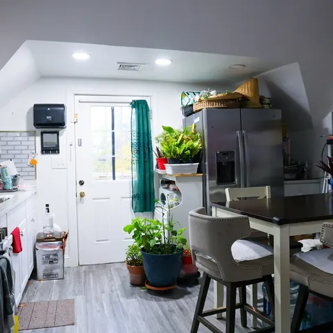 a kitchen with stainless steel appliances kitchen island granite countertop a table and chairs in it