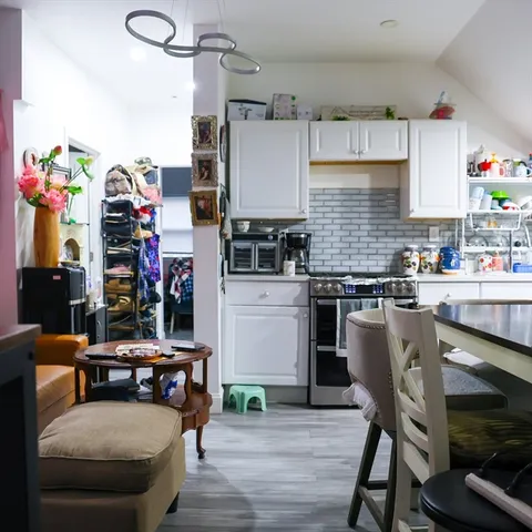 a kitchen with granite countertop a stove and white cabinets