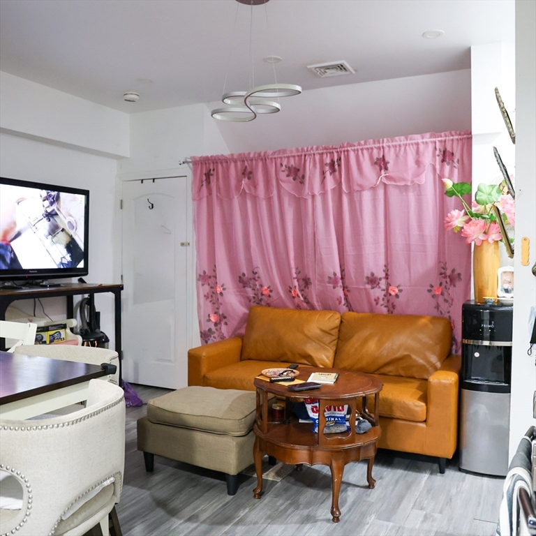 84 Cambridge Street Lowell, MA 01851 - Photo 24 of 42 a living room with furniture and a flat screen tv