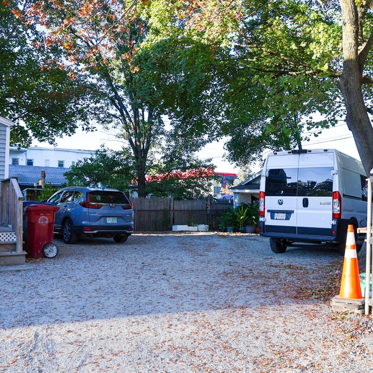 84 Cambridge Street Lowell, MA 01851 - Photo 38 of 42 a front view of a house with a garden and parking space
