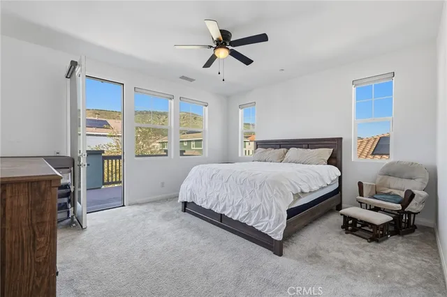 a spacious bedroom with a bed and a ceiling fan