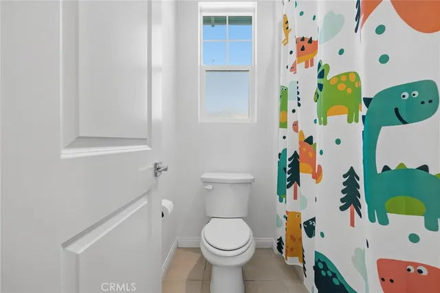 a white toilet sitting next to a white curtain