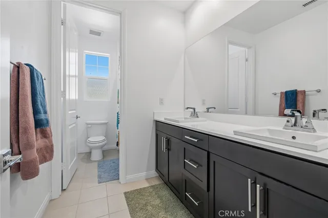 a bathroom with a double vanity sink toilet and shower