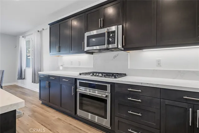 a kitchen with stainless steel appliances wooden cabinets and a stove top oven